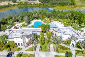 A resort with a swimming pool, landscaped gardens, and a view of a lake. - Amazing New 5 Bedroom 4.5 Bathroom Townhome with Private Pool (Davenport)
