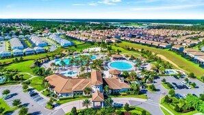 Een resort met meerdere gebouwen, een centraal gelegen zwembad en omliggend groen.