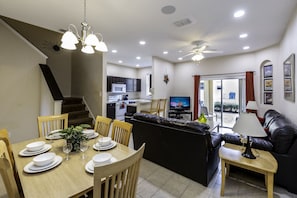 Relax in this open-plan living space featuring a dining area with a table for four and a seating area with a sofa and coffee table.