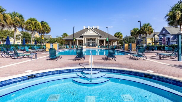 A swimming pool with lounge chairs and a building in the background. - Great location 4Bed 3bth Townhouse with kids themed room (Kissimmee)