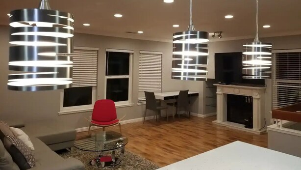 A modern living room with a glass table, red chair, and a fireplace. - A Luxury Urban Getaway Walk to Stanford #2333 (Palo Alto)