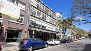 A multi-story building with a sign advertising 'Lease Raywhite' apartments.