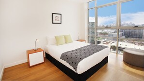 A modern bedroom with a large window, a bed, a nightstand, and a framed picture on the wall. - Modern and Bright 3BR Executive Apartment in Zetland with Views (Zetland)