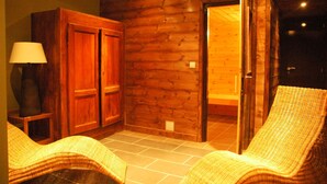 Een kamer met houten wanden, een betegelde vloer en rieten meubels.