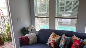 A living room with a dark blue sofa, patterned rug, and colorful pillows. - Pool Guesthouse near Hollywood & Studios (Burbank)