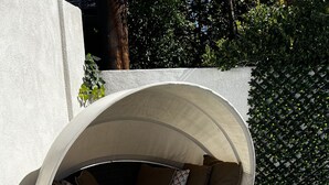 A covered outdoor seating area with cushions and a table with drinks. - Pool Guesthouse near Hollywood & Studios (Burbank)