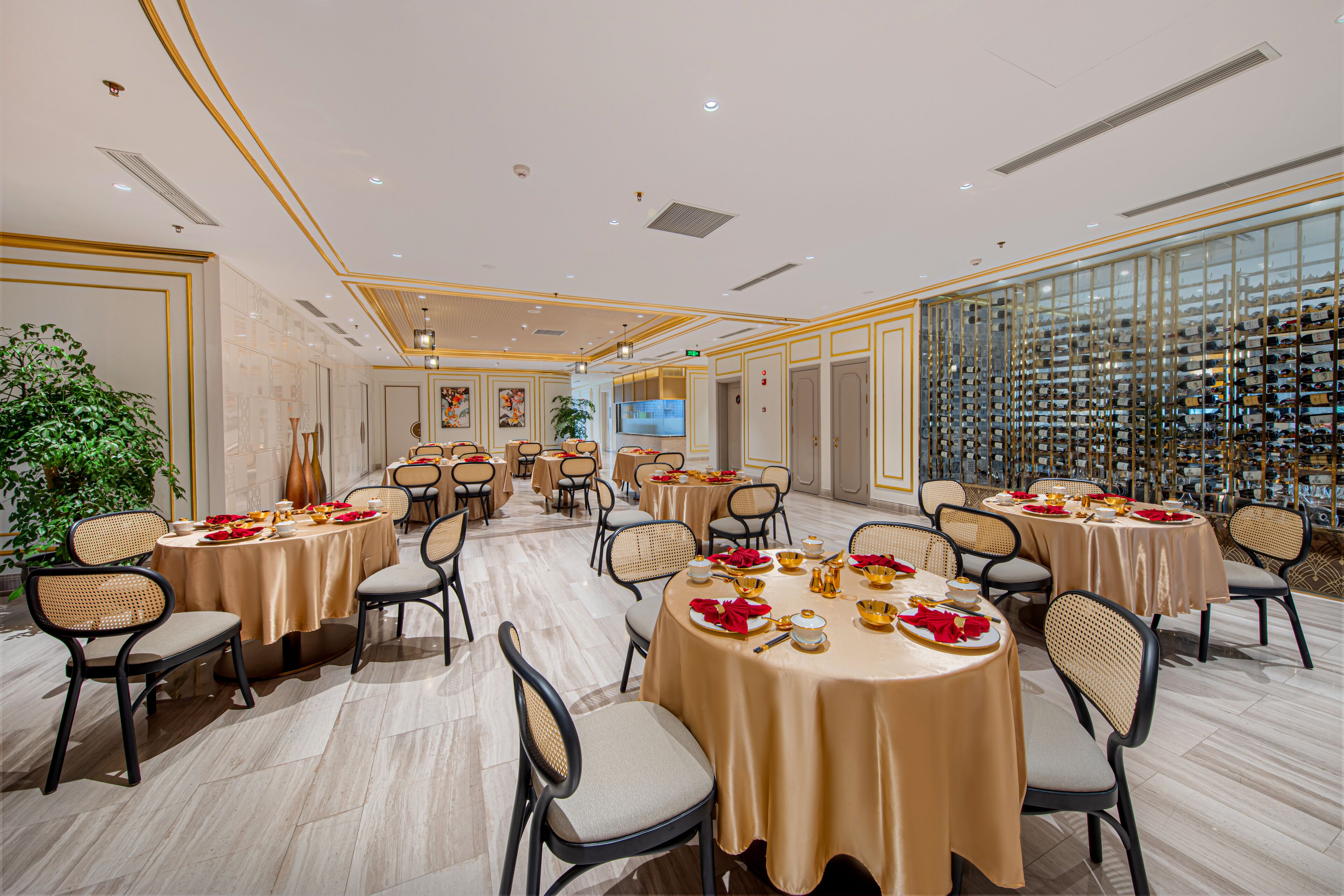 A spacious banquet hall with multiple round tables set for dining, surrounded by comfortable chairs.