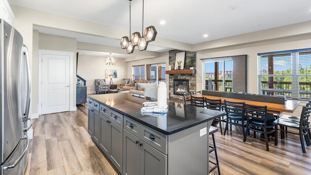 A spacious kitchen with a large island, modern appliances, and a dining area with a view. - Breathtaking Home! *In Town*Fire-Pits* Indoor Pool*Yard Games*Golf View* (Branson)