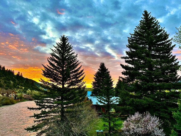 A forested landscape with a river, houses, and a sunset. - On the Banks of the River with Direct ATV Access to National Forest Roads. (South Fork)