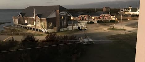 A coastal hotel with multiple buildings, a beach view, and a sign reading 'Ocean Air.'