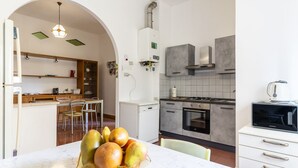 Eine moderne Küche mit Kochinsel, Essbereich mit Stühlen und einem eingebauten Backofen.