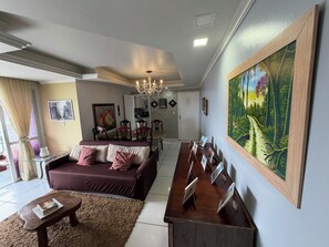 Un salon moderne avec un canapé, une table basse et un tableau accroché au mur.