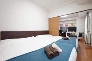 A hotel room with a large bed, a desk, a chair, a television, and a mirror. - IKminami6jo residence 101 (Sapporo)