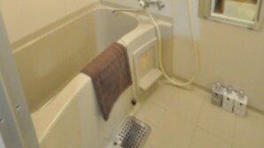 A bathroom with a bathtub, a towel rack, a mirror, and a shower. - IKminami6jo residence 101 (Sapporo)