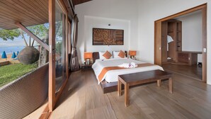 Une chambre spacieuse avec un grand lit, un plancher en bois et une vue sur la mer.