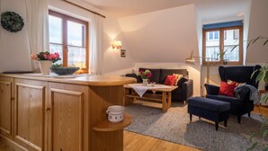 Una sala de estar acogedora con un aparador de madera, un sofá, una mesa de centro y un sillón.