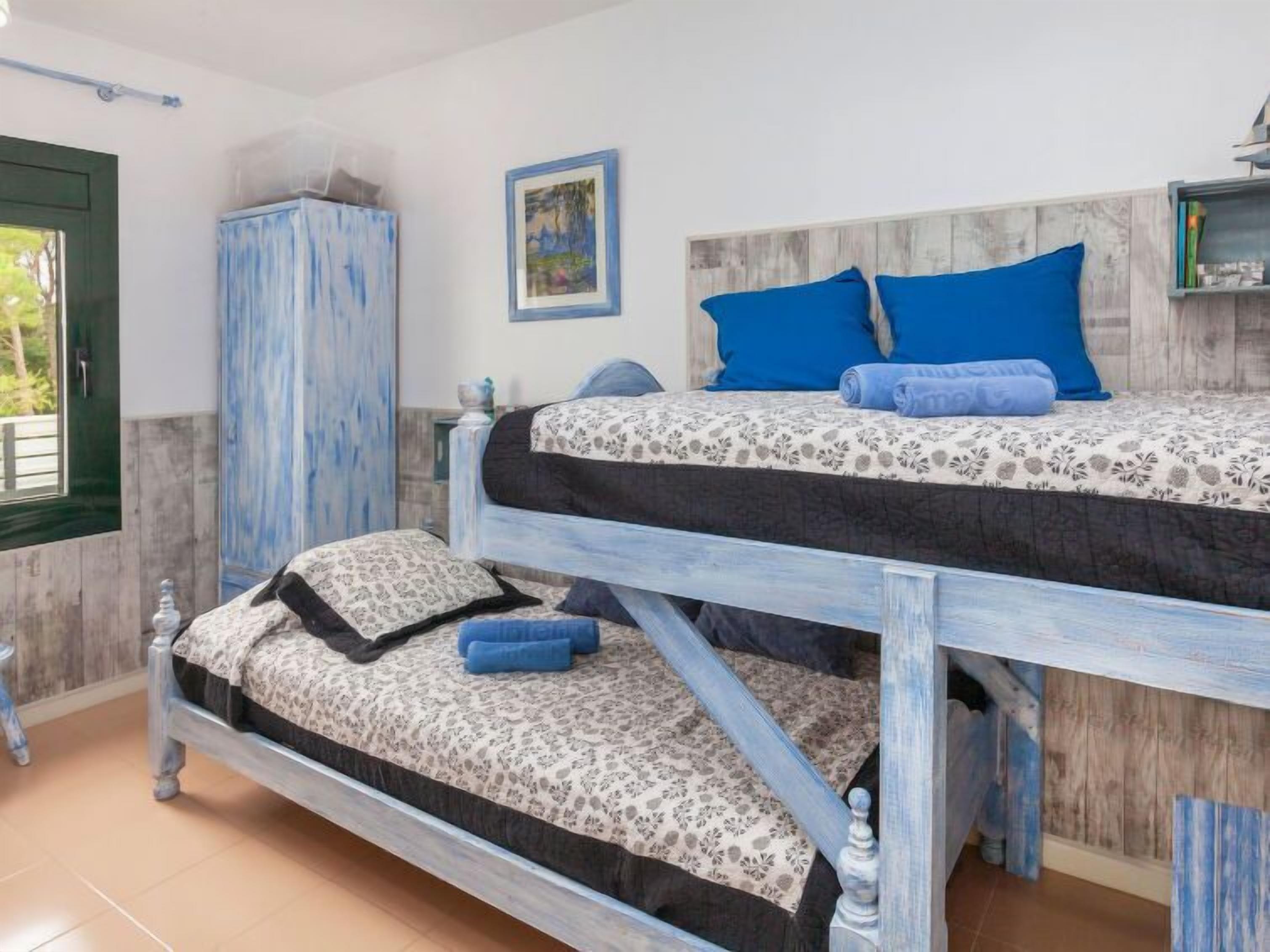 A bunk bed with a floral-patterned bedspread and blue pillows.