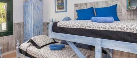 A bunk bed with a floral-patterned bedspread and blue pillows.