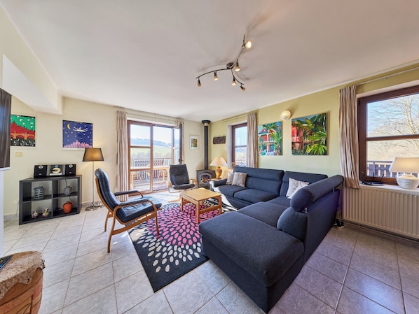 A living room with a sofa, chairs, a coffee table, a fireplace, and artwork on the walls.