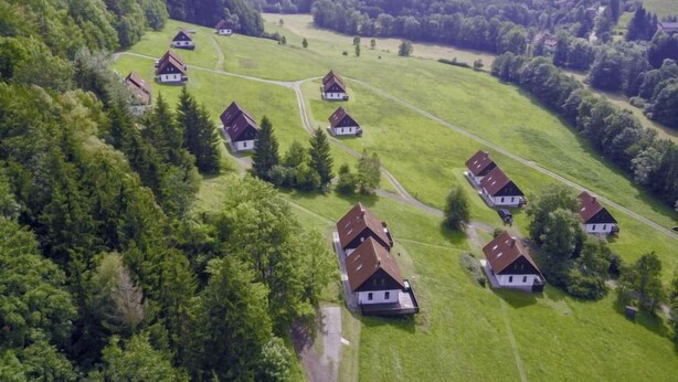 An aerial view of a rural village with traditional houses, surrounded by lush greenery and rolling hills. - Green Valley Park Stárkov 6 by Interhome (Stárkov)