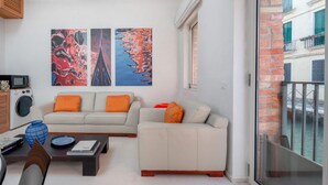 A modern living room with a sofa, coffee table, and artwork on the wall. - The Waterview Alcove (Venice)
