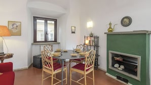 Ein Essbereich mit einem runden Tisch, vier Stühlen und einem grünen Kamin.