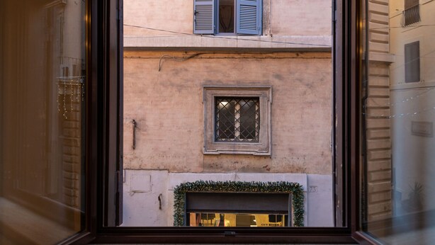 A view through a window of a building with a small window and a door below it.