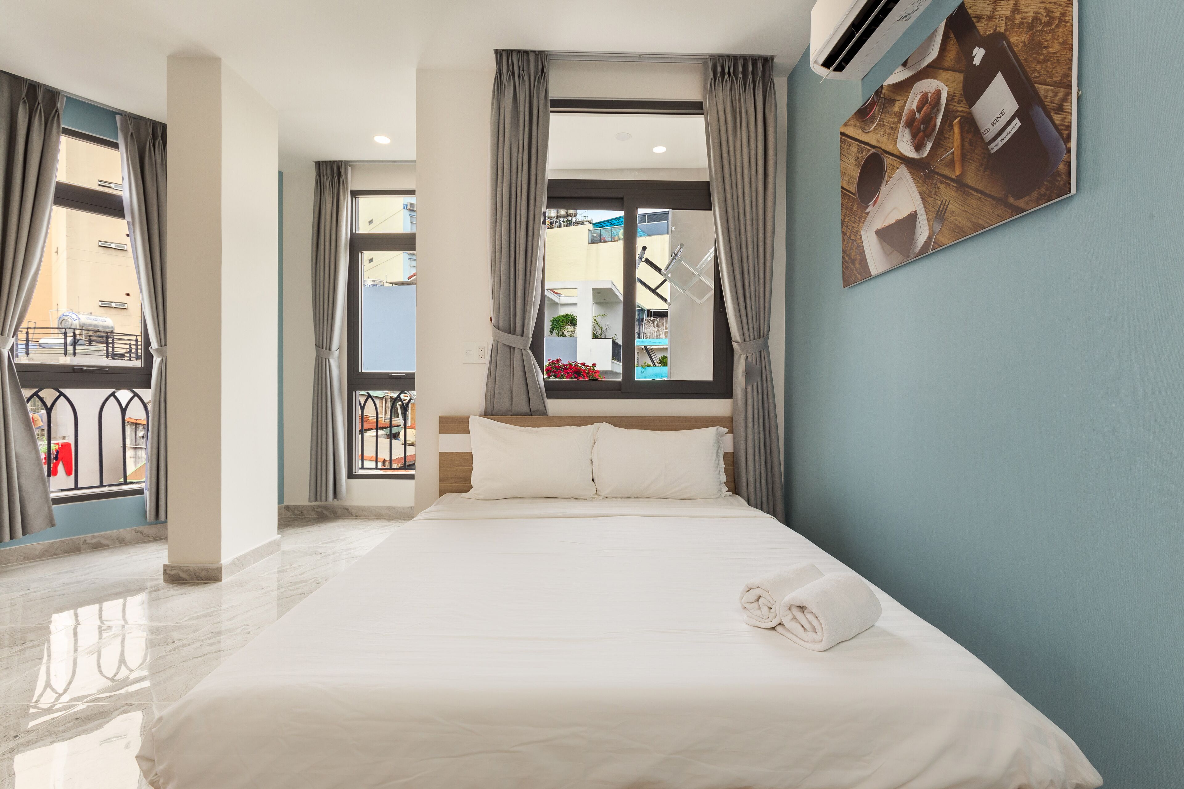 Ein Hotelzimmer mit Bett, einem Vorhangfenster, einer Wandklimaanlage und Blick auf den Balkon.