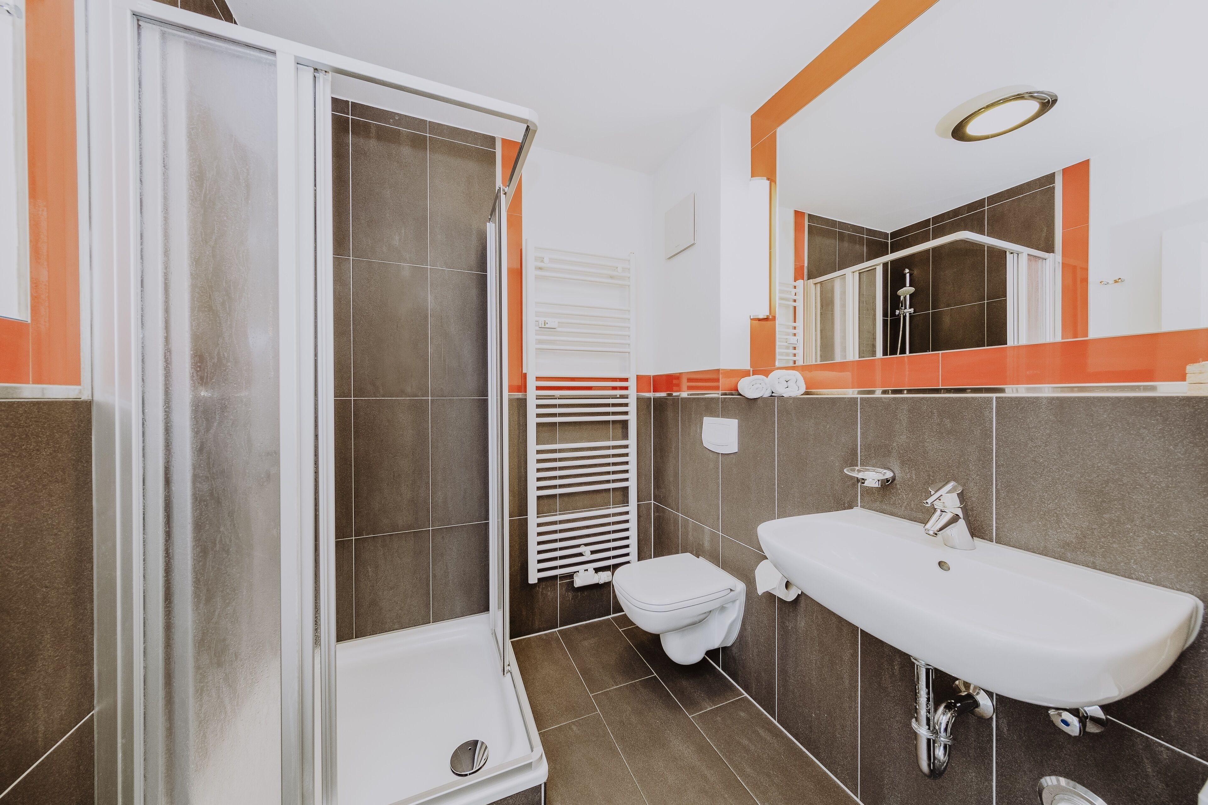 Un baño moderno con ducha, inodoro y lavamanos.