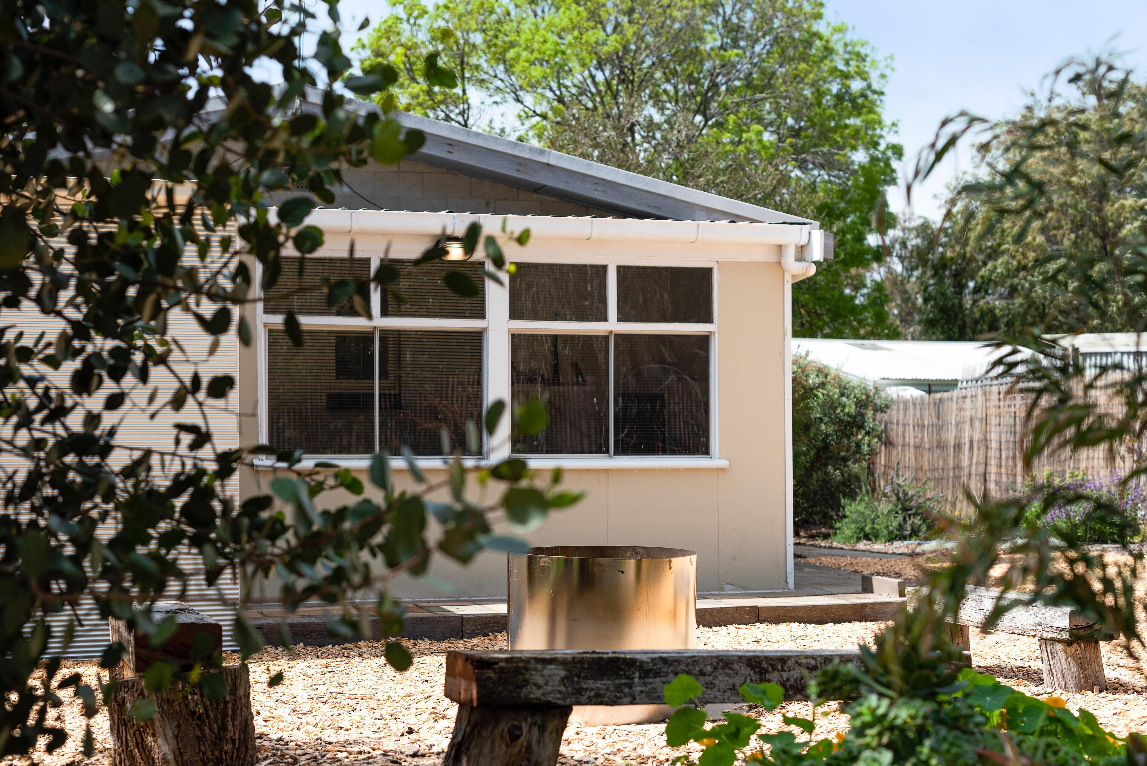 A small, single-story building with a flat roof and a large window.