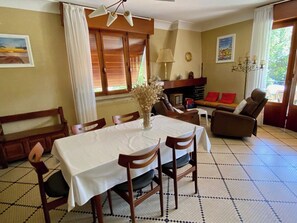 A dining area with a table set for four, a sofa, and a chair. - Vintage style in central location, walkable A0365 (Lège-Cap-Ferret)