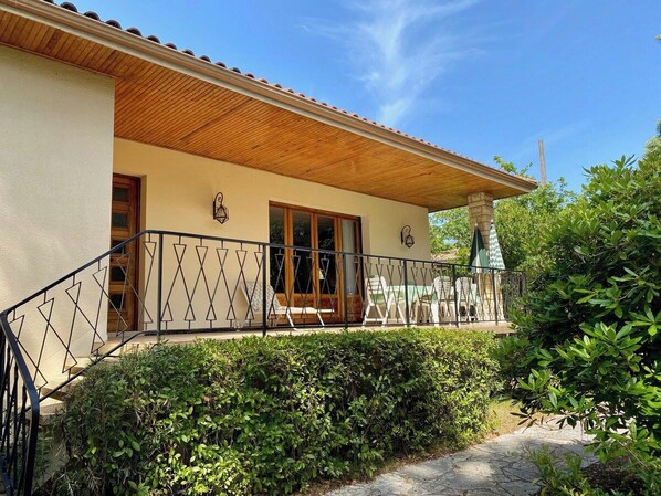 A two-story building with a covered patio area, a wooden ceiling, and a stone staircase. - Vintage style in central location, walkable A0365 (Lège-Cap-Ferret)