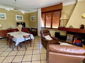 Ein Essbereich mit Tisch und Stühlen, einem Kamin und einem Fernseher.