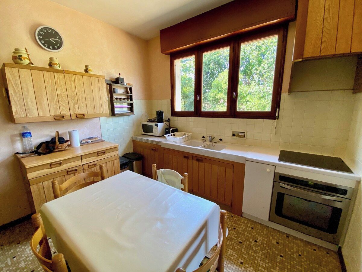 A compact kitchen with a wooden cabinet, a microwave, a sink, and an oven.