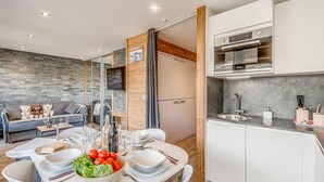A modern kitchen with white cabinets, a stainless steel oven, and a built-in sink. - Renovated Studio 4 pax - Ski-in/Ski-out with WiFi (Tignes-Le Lavachet)