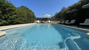 A clear swimming pool with lounge chairs and a hedge surrounding it. - Charming villa for 4 people, private pool between sea and mountains  (Aléria)