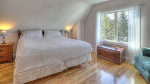 A bedroom with a bed, bedside tables, a window with curtains, and a view of trees. - 🐾Lakeview on Main - Located in the village of Rangeley with water views! Dog Friendly (Rangeley)