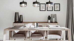 A modern dining area with a wooden table and four upholstered chairs. - Alpenstern Panoramalodgen (Damüls)