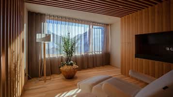 Relax in this stylish living room with a large window, flat-screen TV, and comfortable sofa.