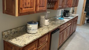 A kitchen with wooden cabinets, a granite countertop, a blender, a coffee maker, and a dishwasher. - 2Kings 7Queens 2Twins 2Fulls - Pool Table - Near BoatRamp&Beach (Kingston)