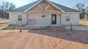 A small brick building with a gabled roof, a flag, and a plaque. - 2Kings 7Queens 2Twins 2Fulls - Pool Table - Near BoatRamp&Beach (Kingston)