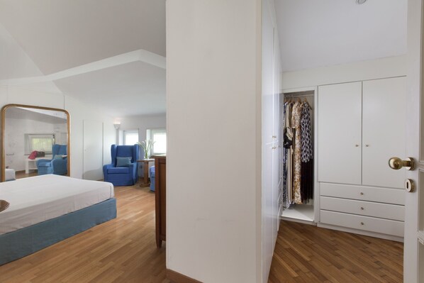 A bedroom with a bed, a wardrobe, a chair, and a desk.