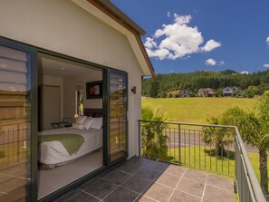 Un dormitorio con cama, mesita de noche y ventana.