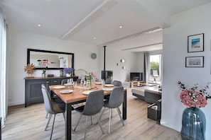 Un espace de vie moderne comprenant un coin repas, une cuisine et un salon avec vue.