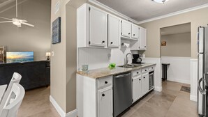 A modern kitchen with white cabinetry, stainless steel appliances, and a granite countertop. - Seascape Resort Villa - Our Happy Place (Miramar Beach)