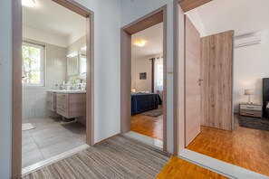 Relax in a spacious room with a large mirror, comfortable seating area, and natural light pouring in through the windows.