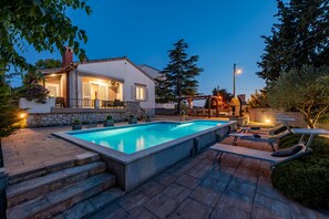 A swimming pool with lounge chairs and a stone staircase leading to a house. - Villa Meštrović ZadarVillas (Zadar)