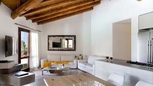 A modern living room with a wooden ceiling, a white sofa, a dining table, and a kitchen area with a refrigerator.