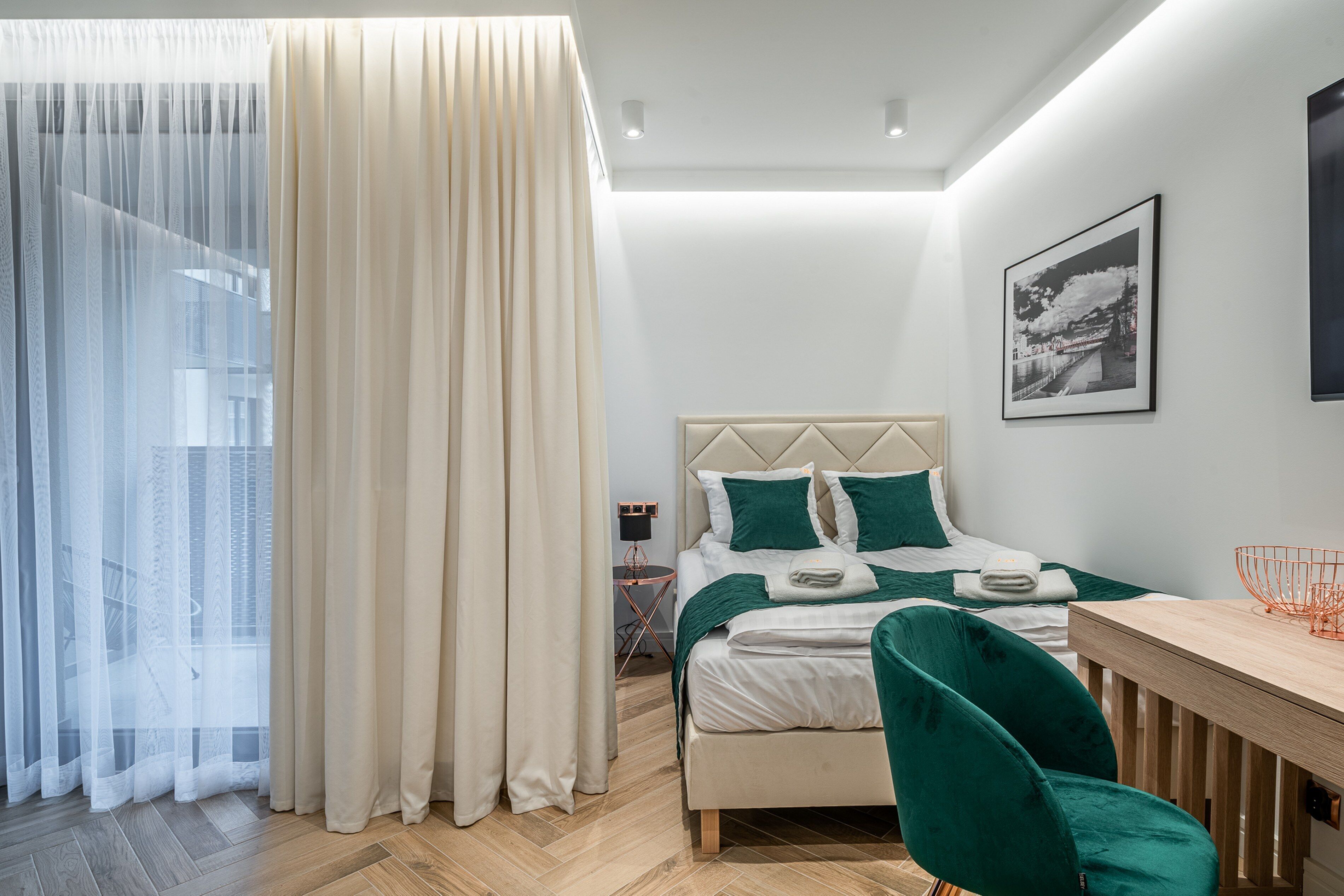 Un dormitorio moderno con cama, escritorio y silla.