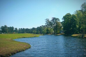 A river flowing through a park with trees and a grassy area. - Family Friendly Villa 1202 with 27 Hole Golf Course Available and Great Resort Amenities by RedAwning (Calabash)